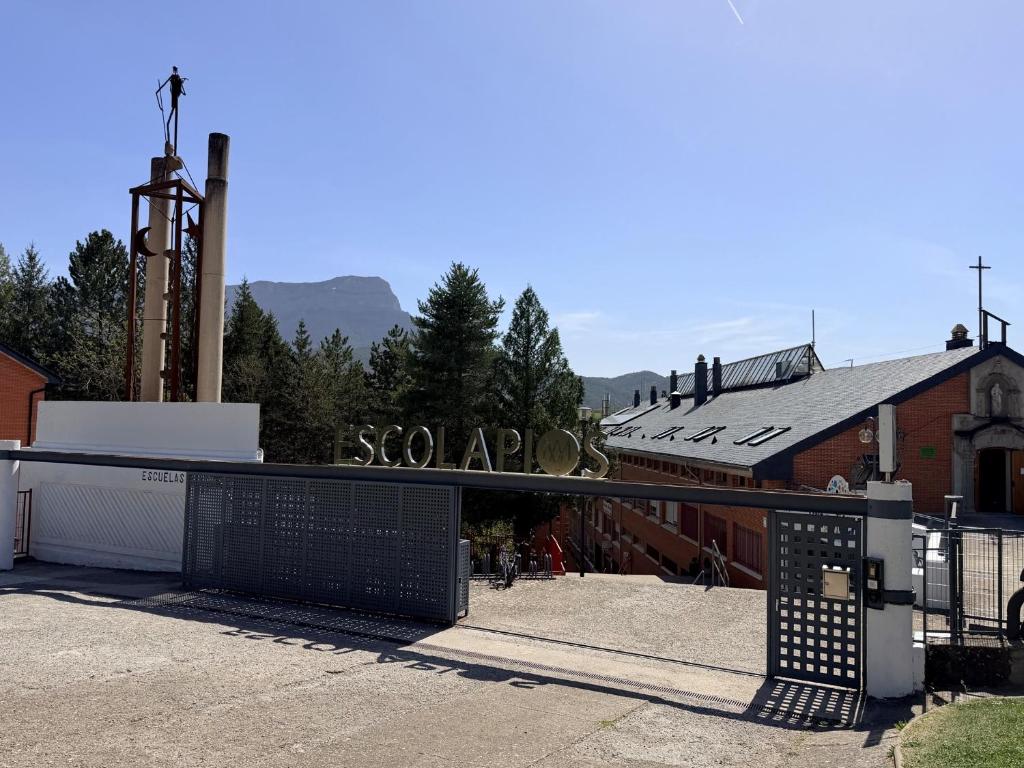 a gate in front of a building with a church at Residencia Albergue Jaca in Jaca