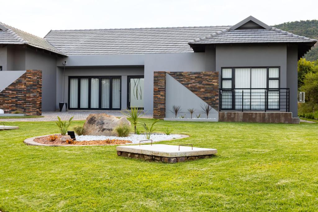 a house with a green lawn in front of it at Villa Limonero in Naboomspruit