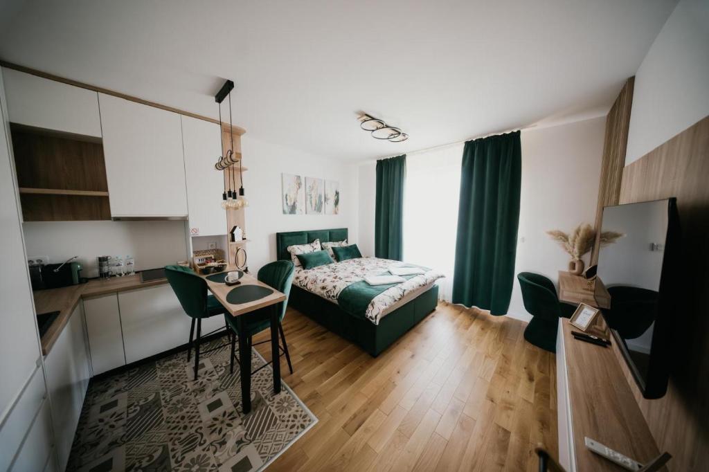 a bedroom with a bed and a table and a kitchen at D Mol Studio apartman in Tuzla