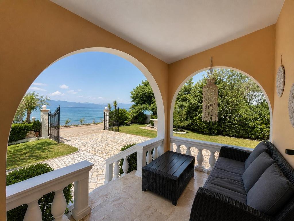 a living room with a couch and a view of the ocean at Villa Antonia- Acharavi beach in Acharavi