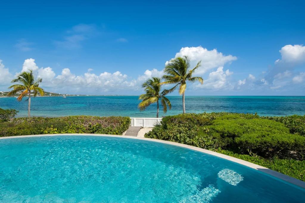 a swimming pool with a view of the ocean at Turtle Beach 5BR Snorkeling Kayaks & Family Entertainment in Providenciales