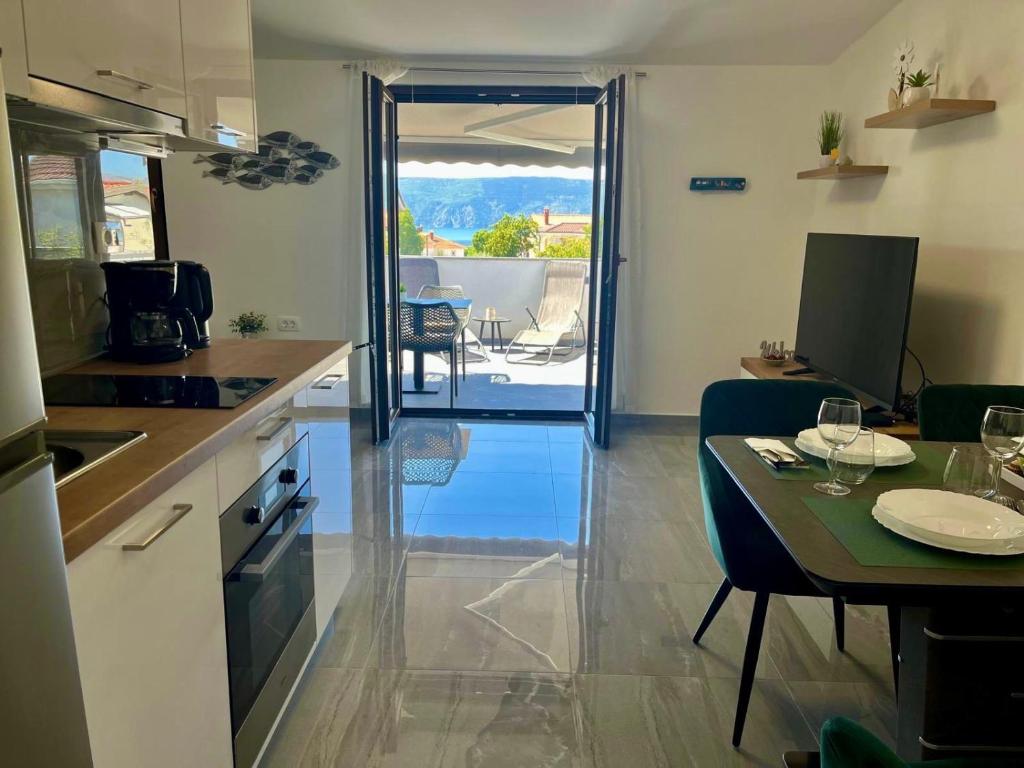a kitchen with a table and a dining room with a view at Apartman Luka in Pinezici