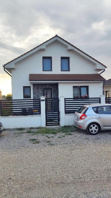 ein weißes Haus mit einem davor geparkten Auto in der Unterkunft SIL House in Sîntandrei