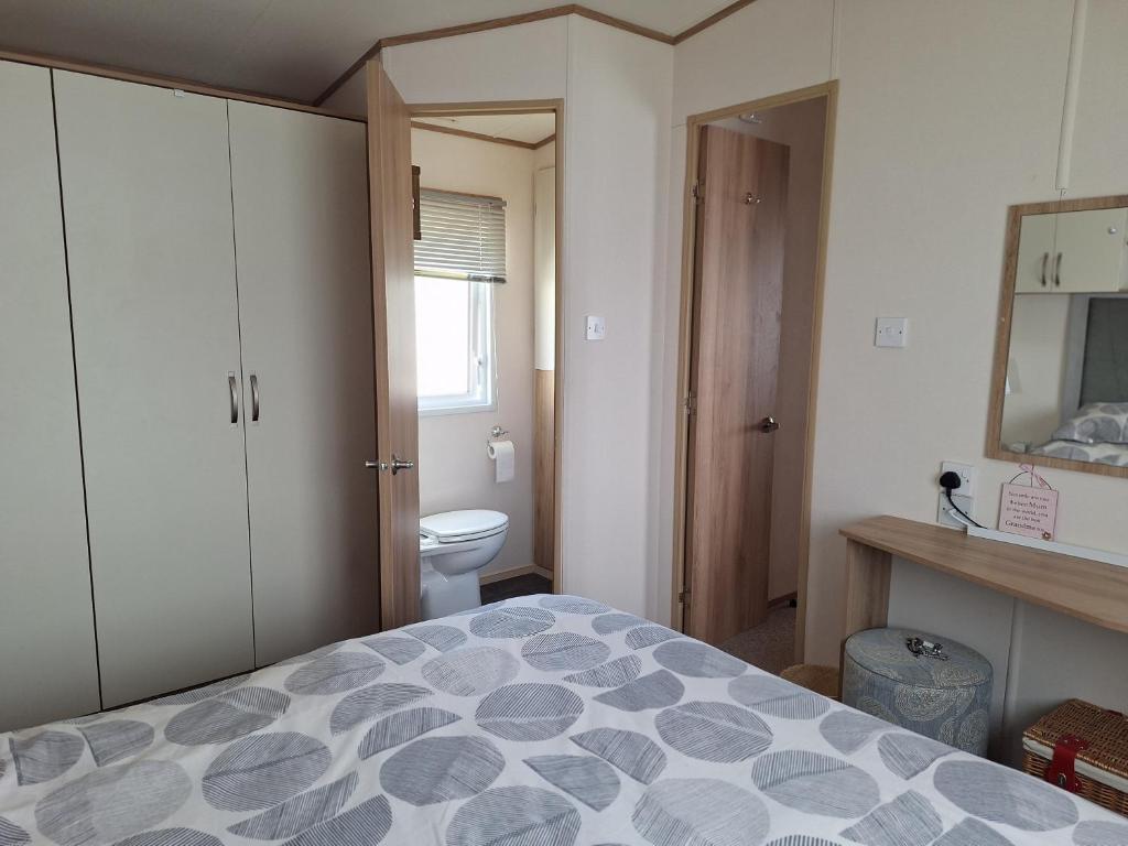 a bedroom with a bed and a bathroom with a toilet at Perranporth Cornwall in Perranporth