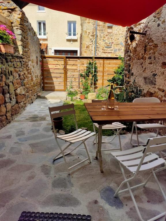a patio with a table and chairs and an umbrella at Maison 2 chambres, pleine de Charme in Vic-le-Comte