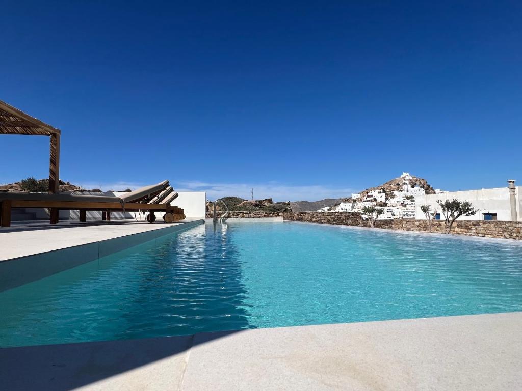 a swimming pool with blue water in a resort at Wabi Aegean Villa in Ios Chora