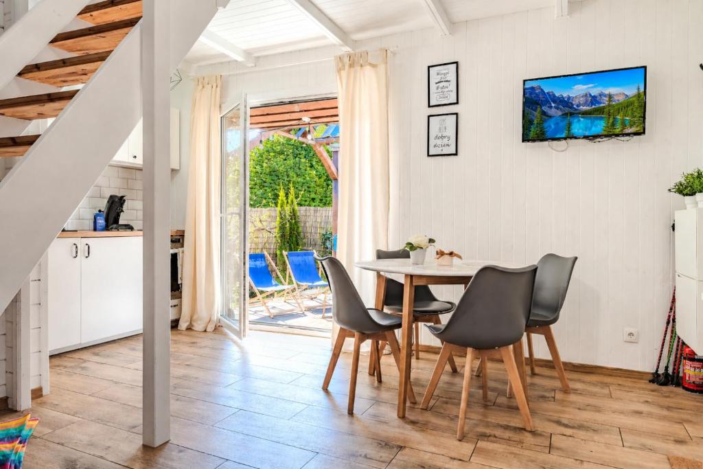 a kitchen and dining room with a table and chairs at Nowoczesny domek z klimatyzacją i tarasem, blisko plaży Stegna House in Stegna