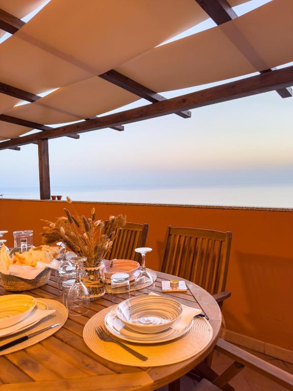 a wooden table with plates of food on it at La Ginestra - Casa Vacanze in Porto Alabe