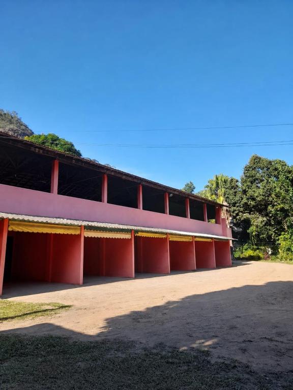 a red building with trees in the background at Pousada Quinta de Areal in Areal