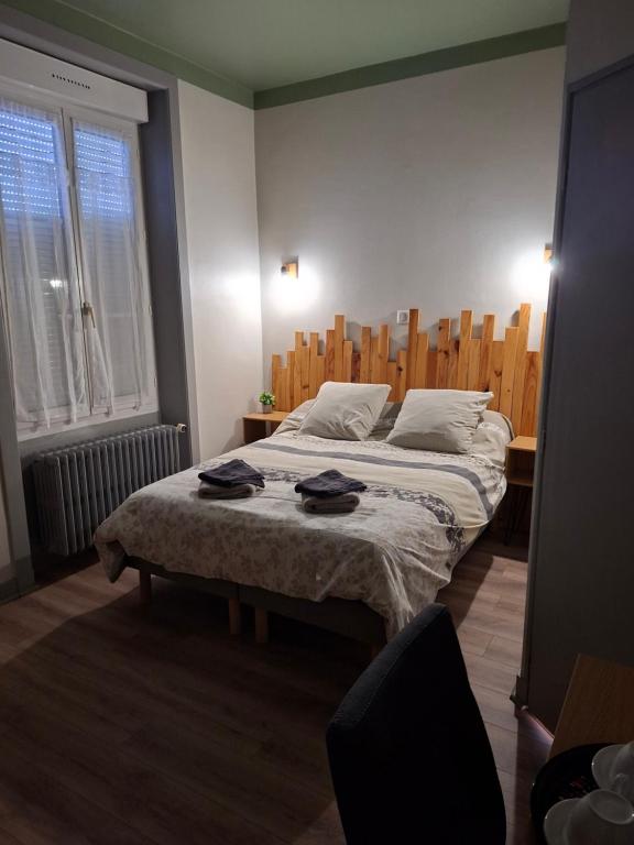 a bedroom with a bed with two clothes on it at Le Café D Ici in Saillat-sur-Vienne