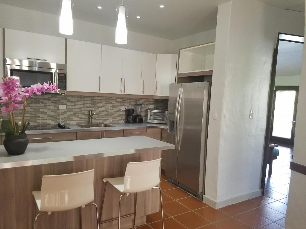 una cocina con armarios blancos y electrodomésticos de acero inoxidable en Holiday Home at Rio Mar, en Río Grande