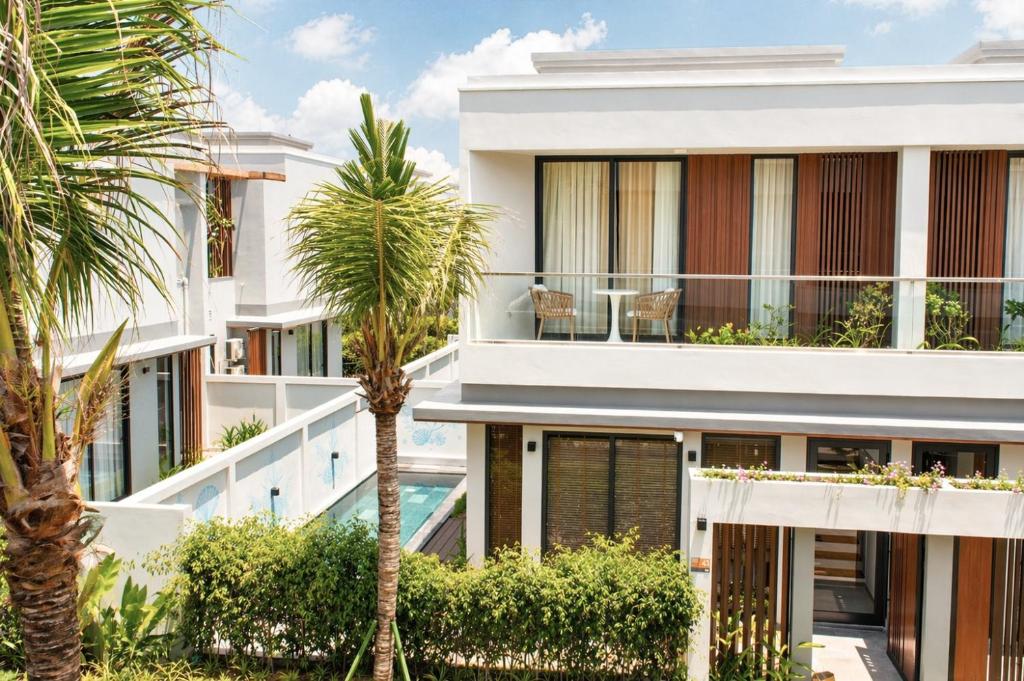 an exterior view of a building with palm trees at Sea La Vie Beachfront Villa - Bai Truong Beach Phu Quoc in Phú Quốc