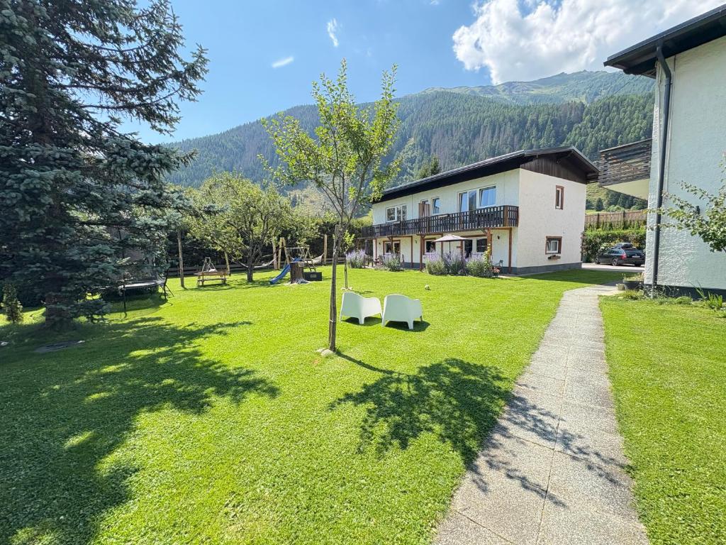 a yard with two chairs and a house at Mallnbach Apartments in Mallnitz