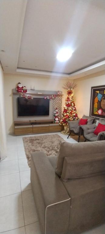 a living room with a couch and a christmas tree at Casa Temporada Garanhuns in Garanhuns