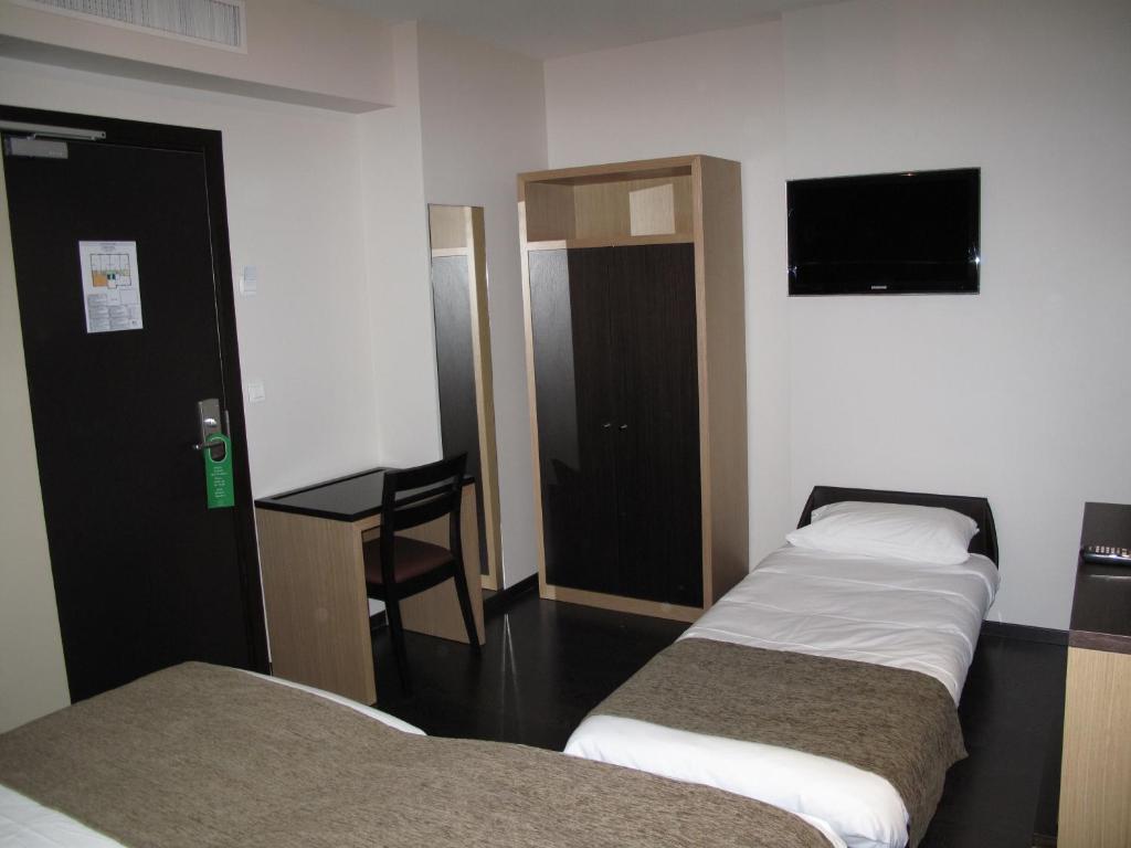 Voodi või voodid majutusasutuse Source Hôtel toas