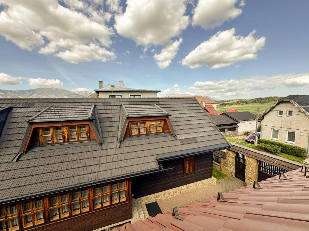 a house with a gray roof and some buildings at Drevenica u Starona in Liptovská Kokava