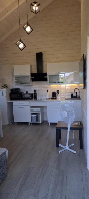 a kitchen with a table and a chair in a room at Domki Amanda in Ustronie Morskie