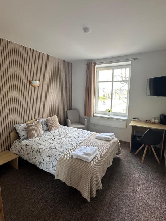 a bedroom with a bed with two towels on it at Vievija Hotel in Vievis