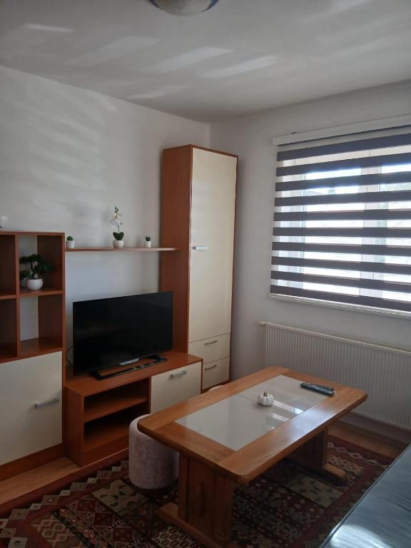 a living room with a coffee table and a television at Apartmani, prenoćište Ana in Tomislavgrad