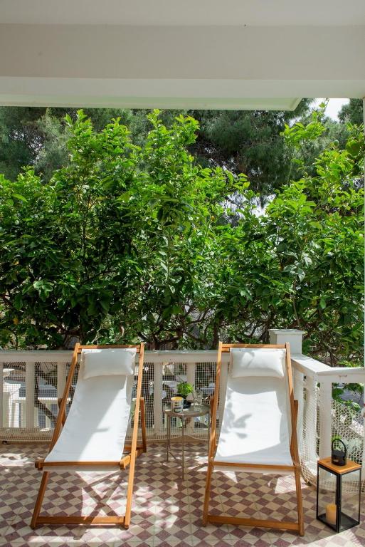 two chairs on a patio with trees in the background at Giannis Papoutsis in Posidhonía