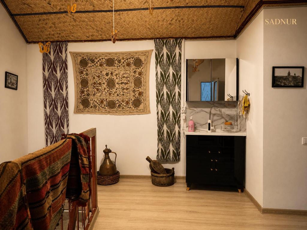 a bathroom with a sink and a mirror on the wall at Family Guest House SadNur in Bukhara
