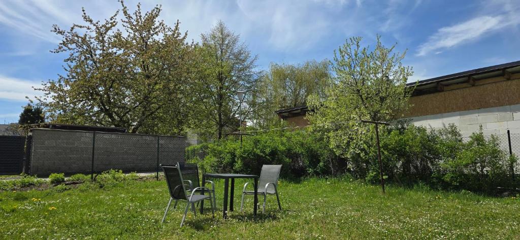 a table and chairs in the grass in a yard at Apartment 35m2 in Karlovy Vary