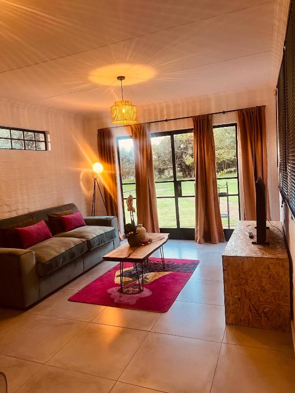 a living room with a couch and a table at Origin Cottage in eMalahleni