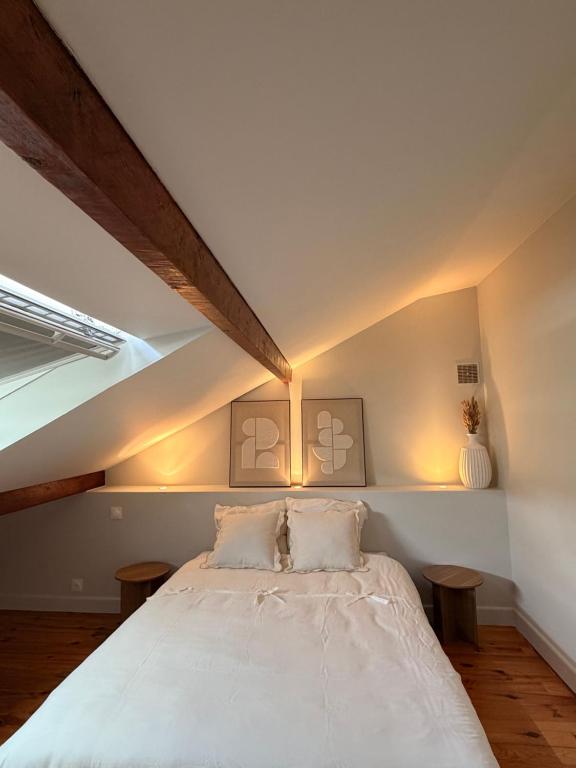 a bedroom with a white bed with two pillows at Chambre 24h Le Mans in Guécélard