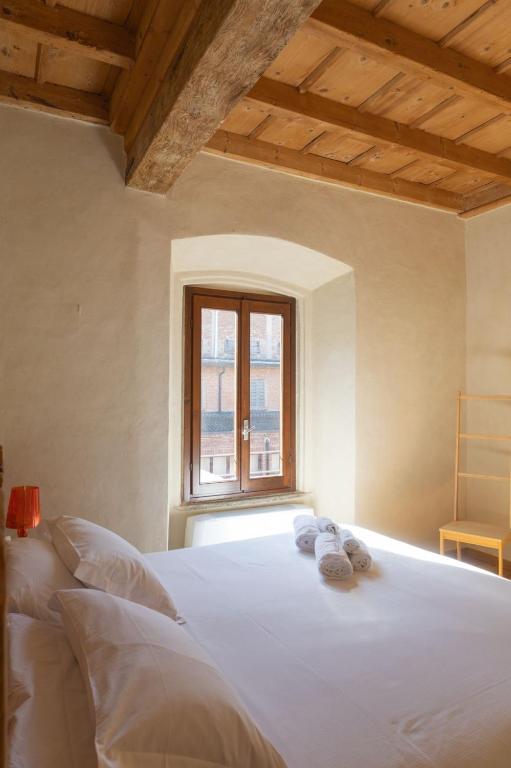 a bedroom with a white bed with a window at Il Carro Rooms - Monza Centro, Tribunale, Ospedale in Monza