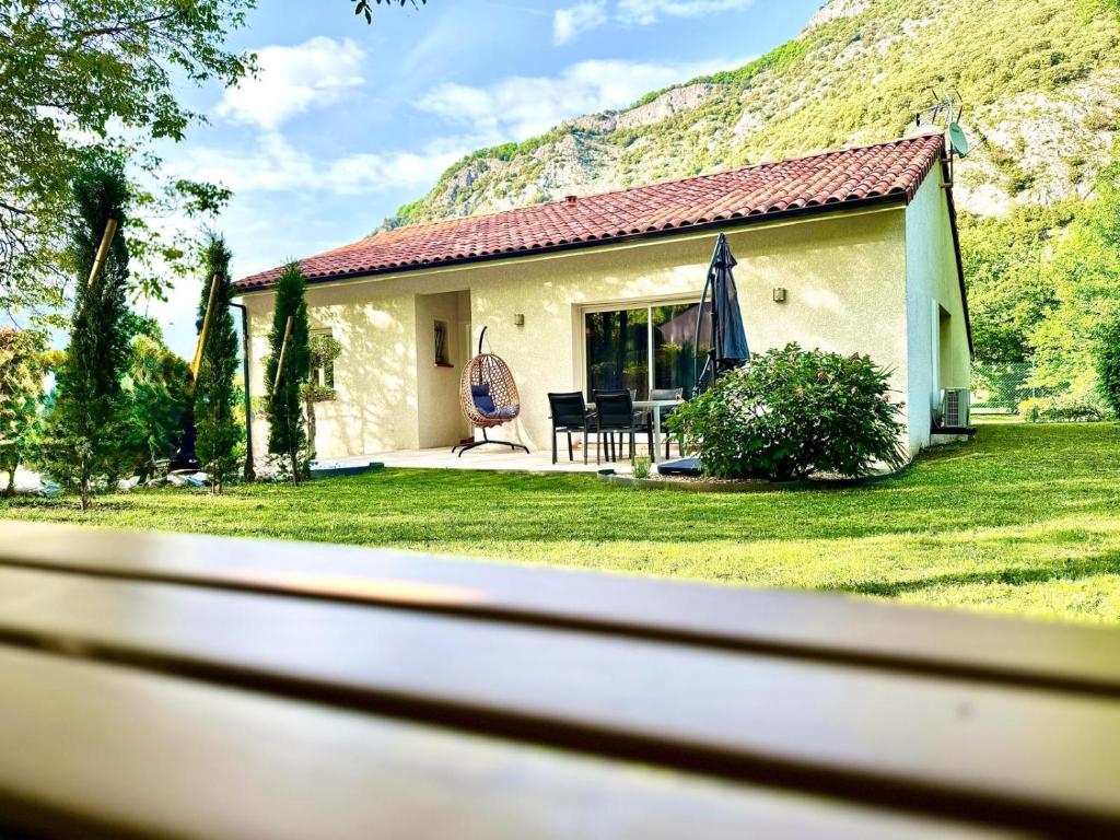a small house with a table and a chair in a yard at L'Écrin d'Ussat in Ussat