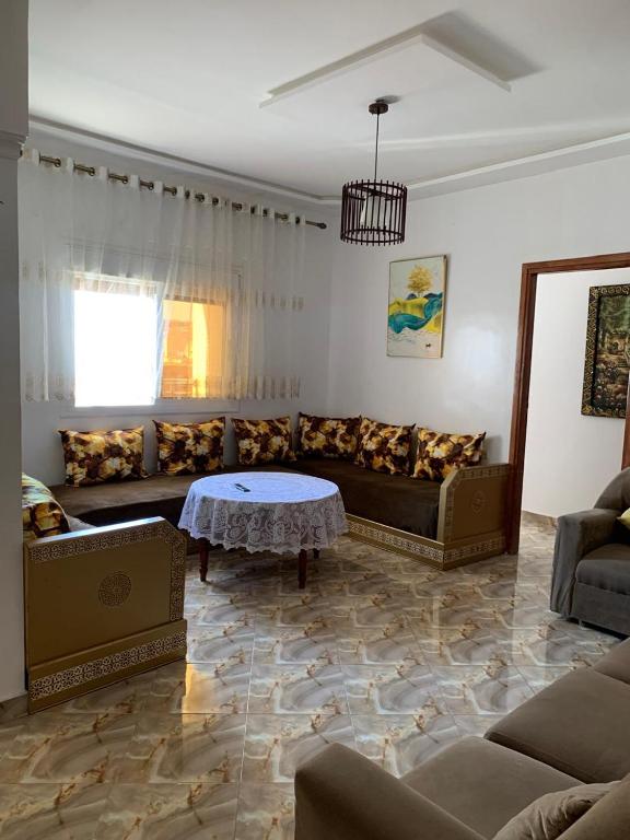 a living room with a couch and a table at Azla Beach Escape - Cozy Apartment in Tétouan