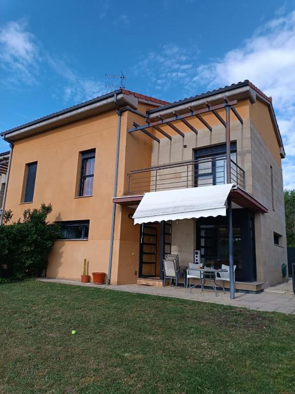 a house with a table and chairs in front of it at La Vega in Cardeñadijo