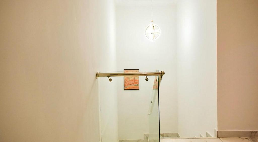 a white wall with a shelf and a sign on it at Amber in Tema