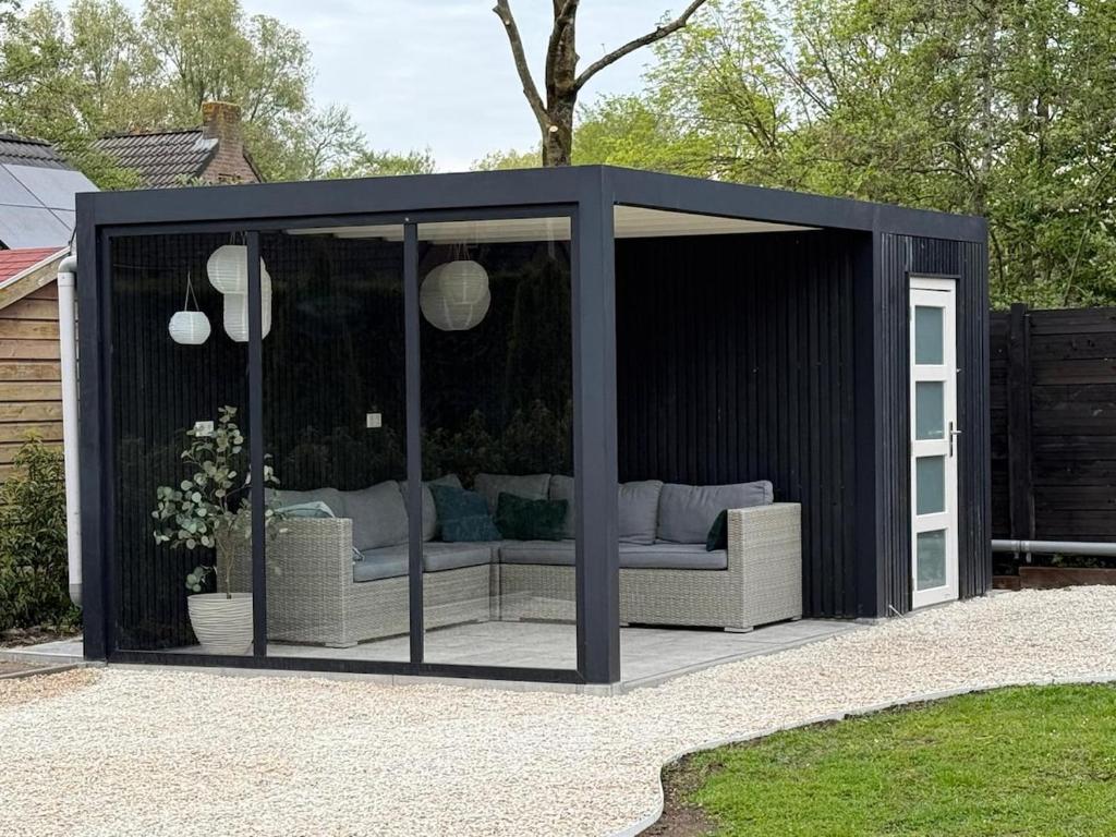 a black shed with a couch in it at Vakantiehuis 6 personen ENL Boutique 92 in Ewijk