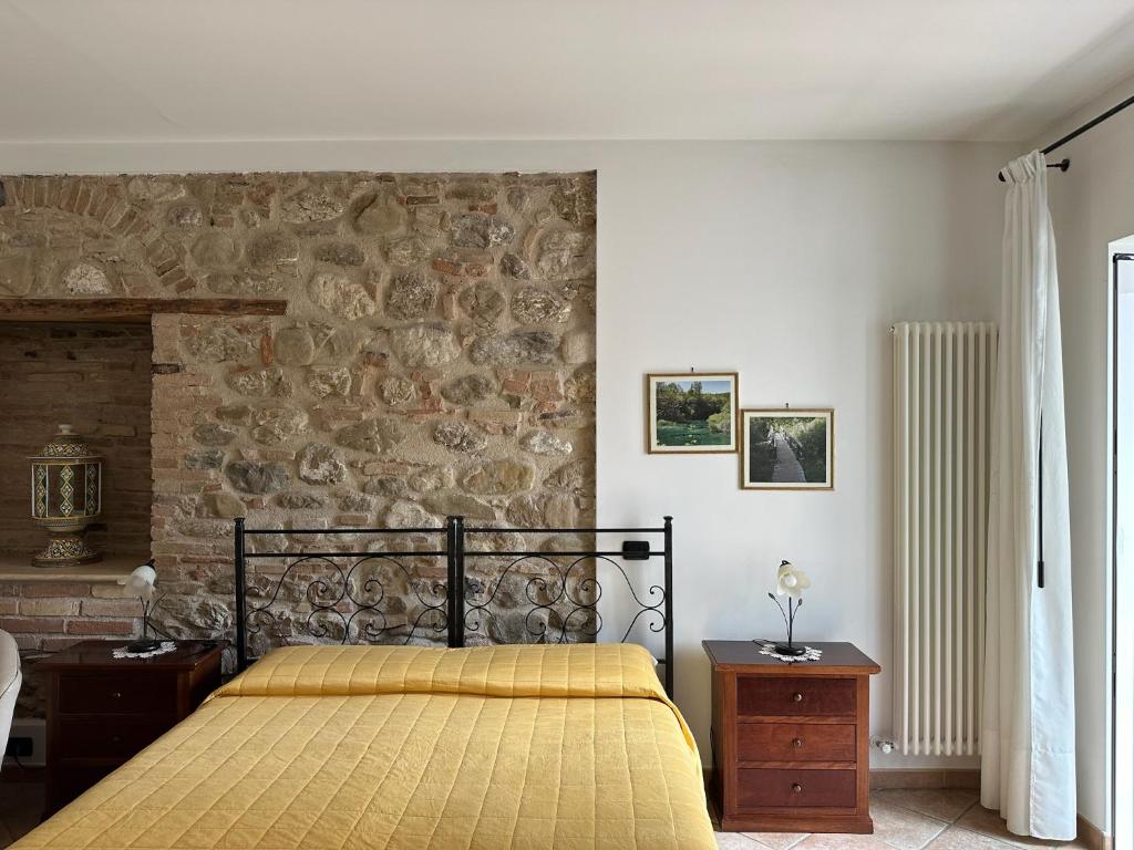 a bedroom with a bed and a stone wall at Antica Interamnia in Teramo