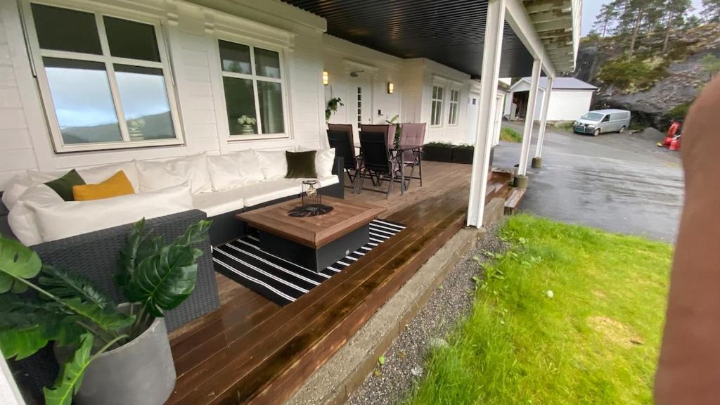 a porch of a house with a couch and a table at Vetlebekken Apartment close to Trolltunga in Steinaberg