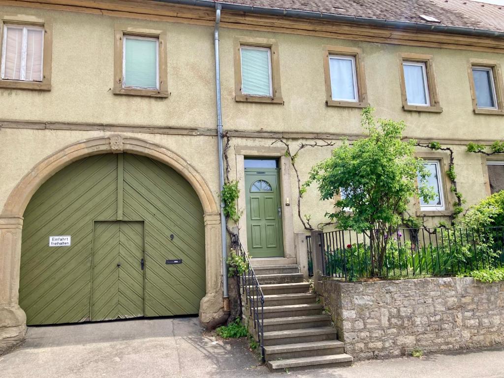 a house with a green door and a staircase at Ferienhaus Alter Hof in Volkach