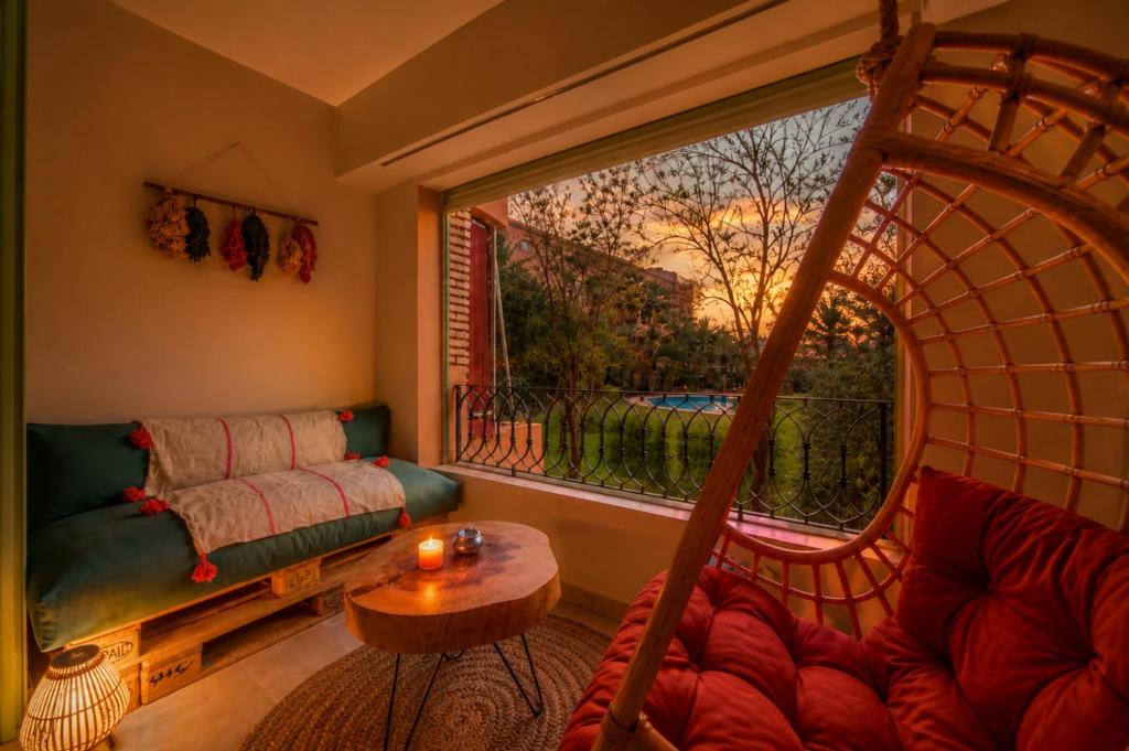 a living room with a couch and a large window at Babylone Appart & Pool, Hivernage in Marrakesh