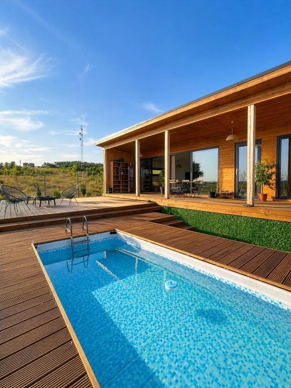 a house with a swimming pool on a wooden deck at Carsium View House in Hîrşova