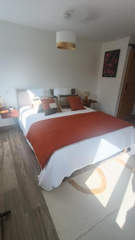 a bedroom with a large bed with a red blanket at Chambre d'hôtes Bidegaina in Ahetze