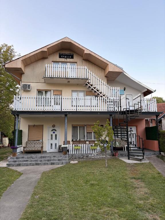a large house with a balcony and a yard at Apartamani Evelin in Veliko Gradište