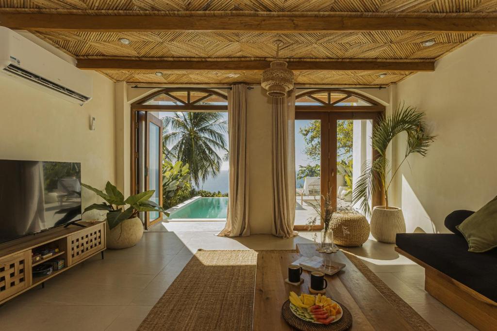 a living room with a tv and a pool at Native Villa with Pool at Kalumo Lodge in Oslob
