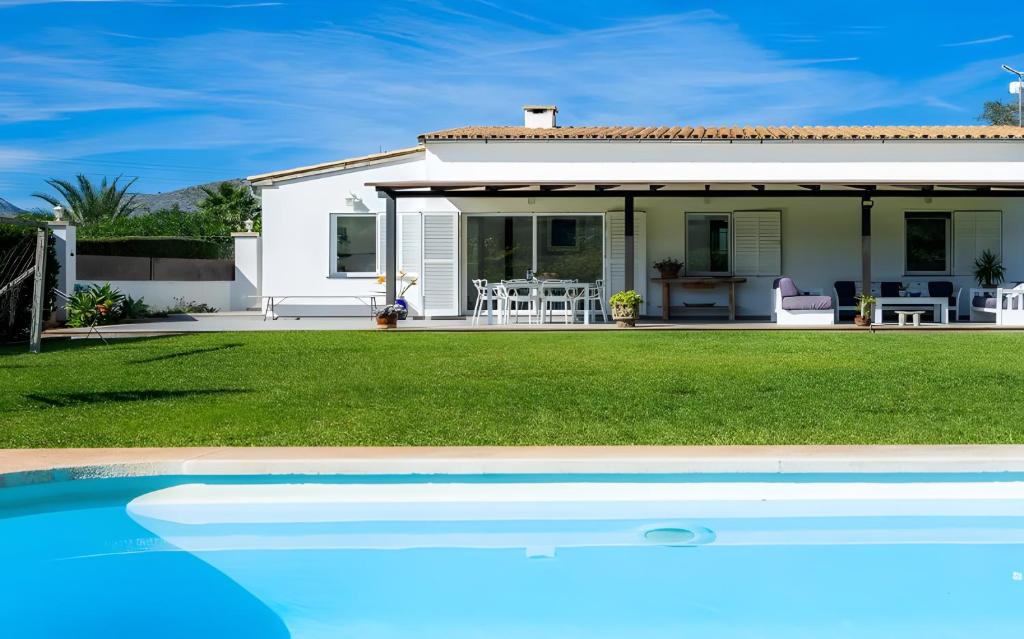 a house with a swimming pool in front of it at Les Herbetes in Port de Pollensa