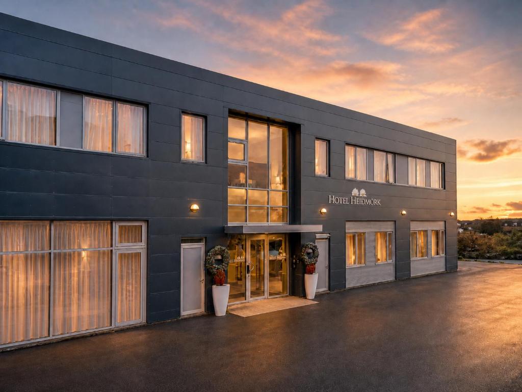 a large black building with a sunset in the background at ASKA Heiðmörk in Reykjavík