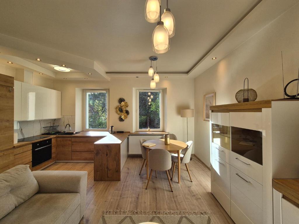 a kitchen and living room with a table and a couch at DORMAR II Apartament in Wałbrzych