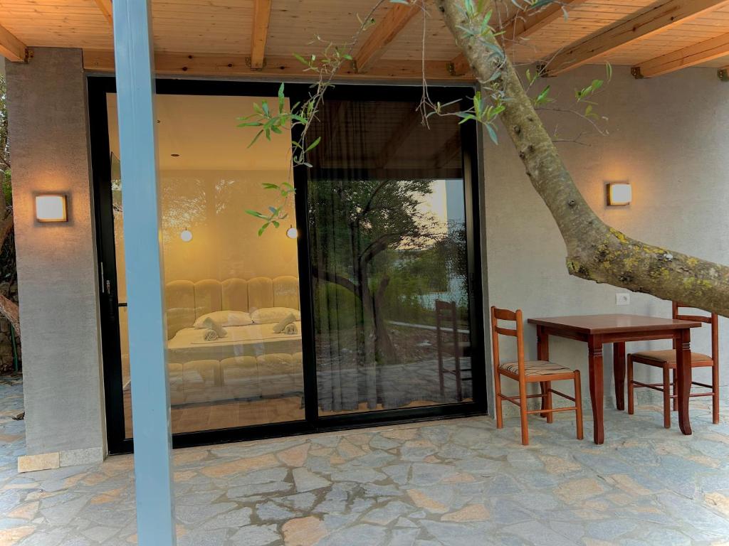 a patio with a table and chairs and a tree at Olive garden private Suite in Ksamil