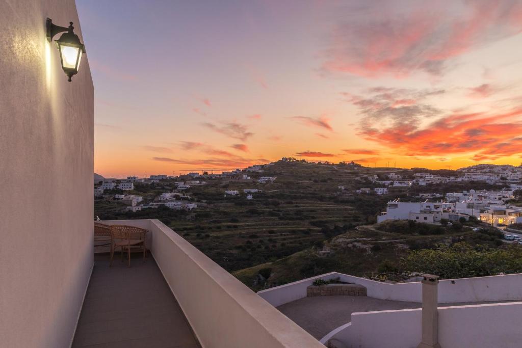 a balcony of a house with a sunset at Artemis Cozy Home in Péran Triovasálos