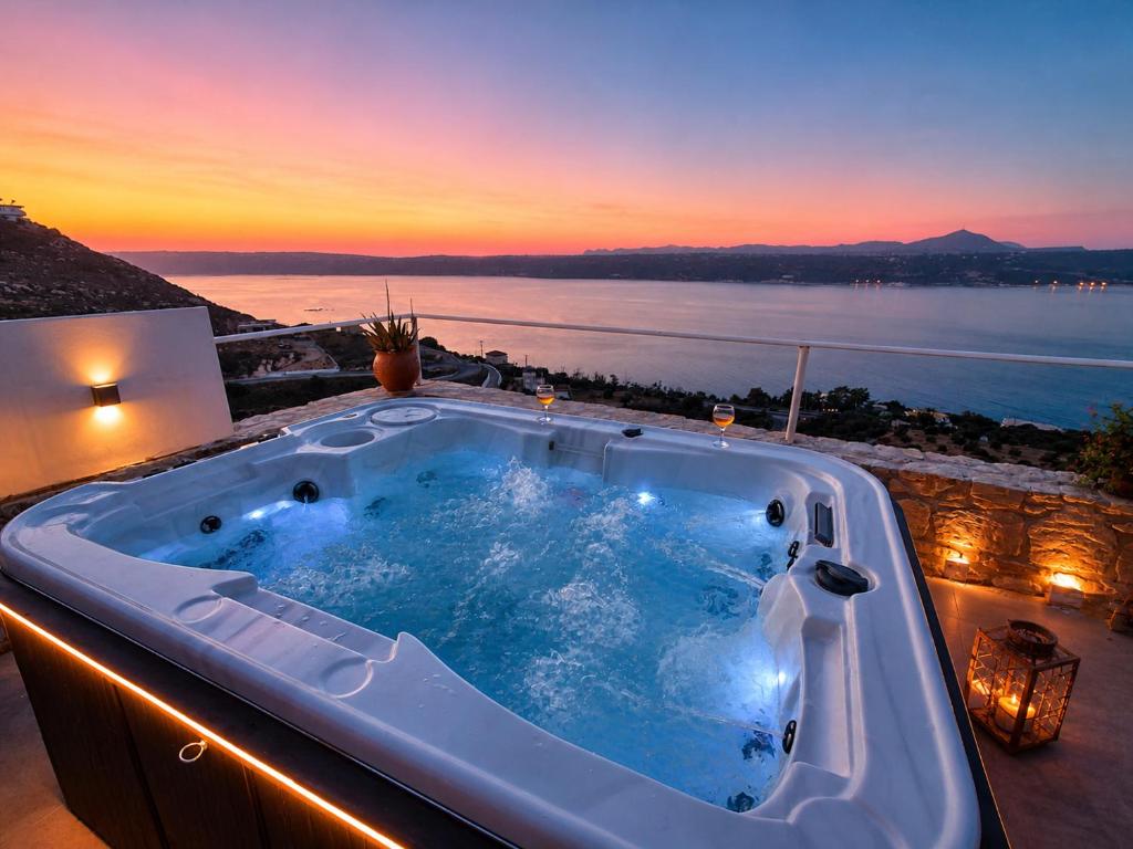 a hot tub on a balcony with a view of the ocean at Aptera Dream Apartment in Áptera
