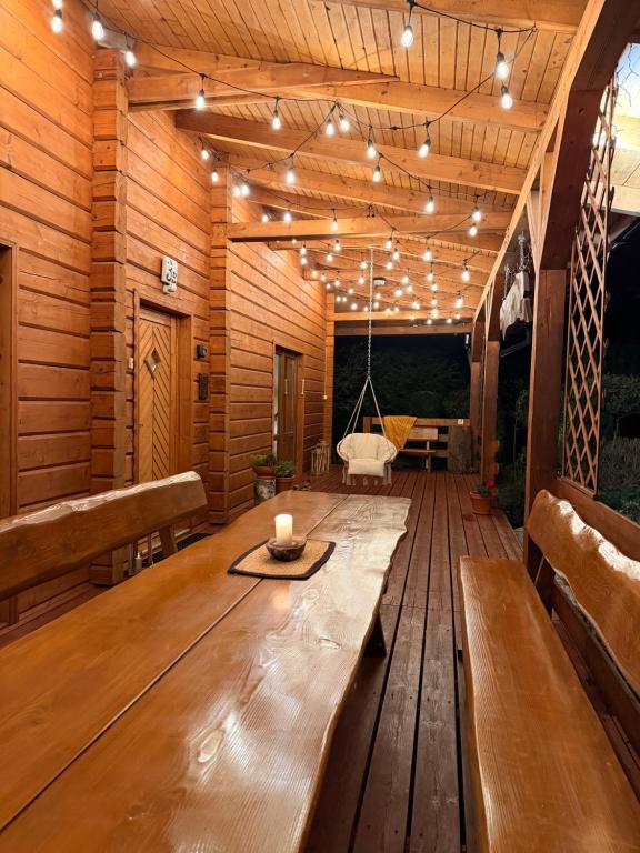 a wooden deck with a bench and a candle on it at Chatka Puchatka in Wisła
