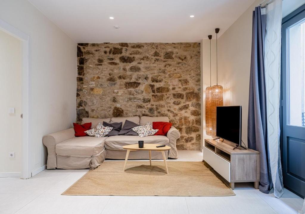 a living room with a couch and a tv at Aromatik apartments in Girona